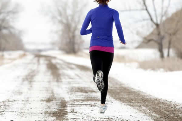 Woman running down the road in winter